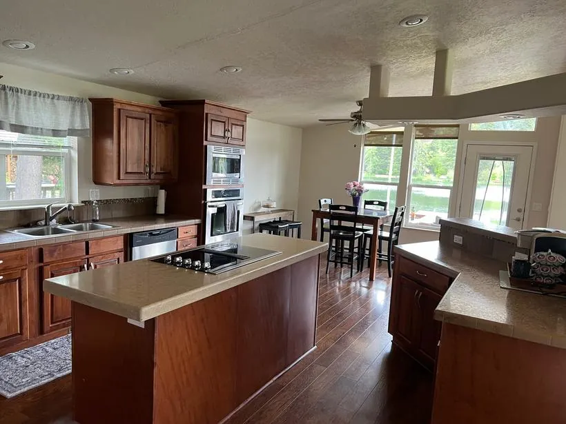 A dated kitchen with dark cherry cabinets and laminate counters, before remodeling