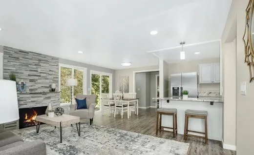 Open living room with a stone fireplace surround and new floors